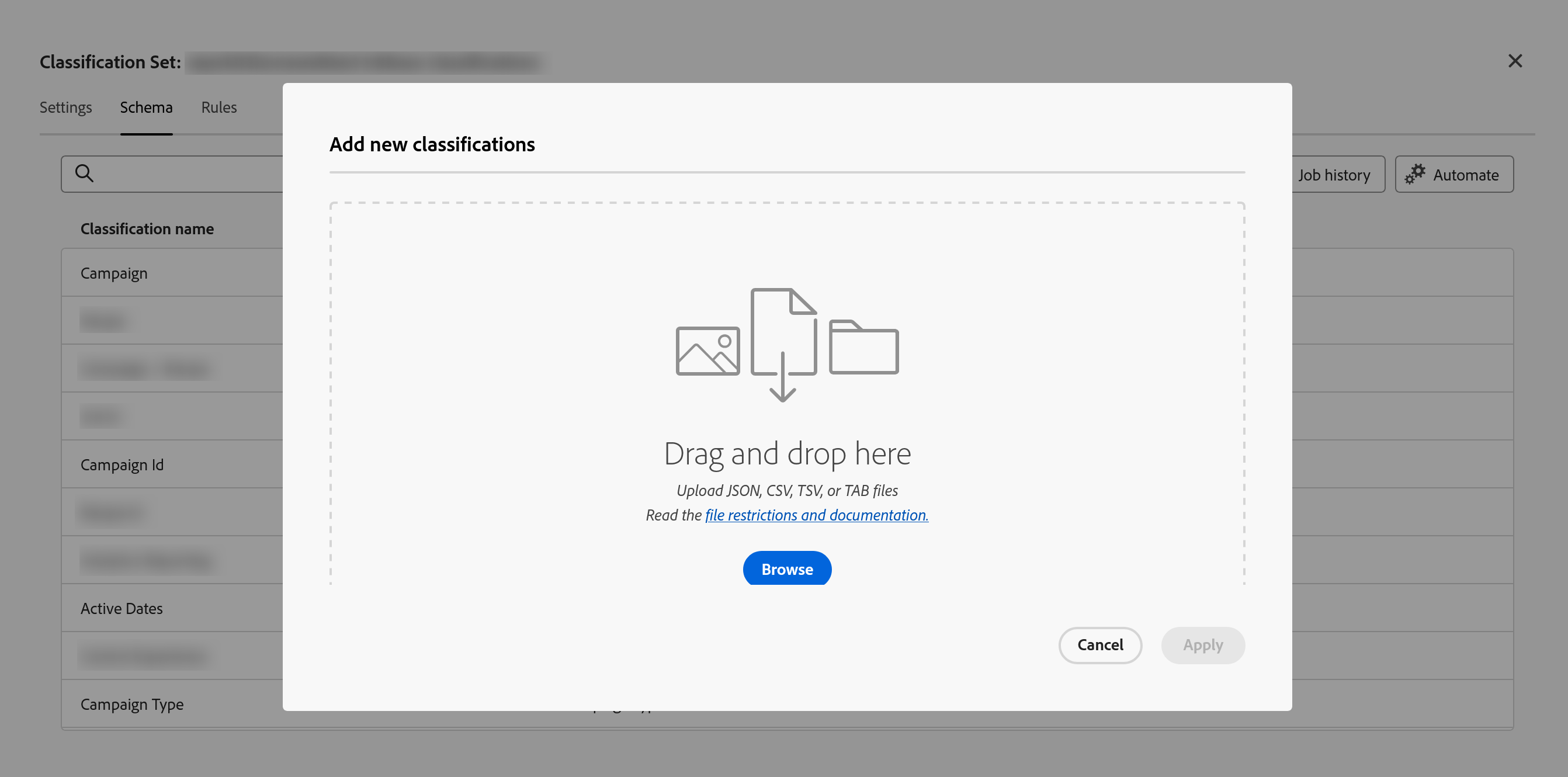 An Add new classifications dialog open over the Schema tab of a classification set. The set name in the header behind is blurred out, and tabs for Settings, Schema and Rules sit beneath it with Schema active. Behind the dialog a Classification name column is partly visible, listing Campaign, Campaign Id, Active Dates and Campaign Type among several entries that are blurred, with Job history and Automate controls to the right. The dialog itself holds a large dashed drop area with a file icon, the words Drag and drop here, a line reading Upload JSON, CSV, TSV, or TAB files, a link to file restrictions and documentation, and a blue Browse button, with Cancel and a greyed-out Apply at the bottom.